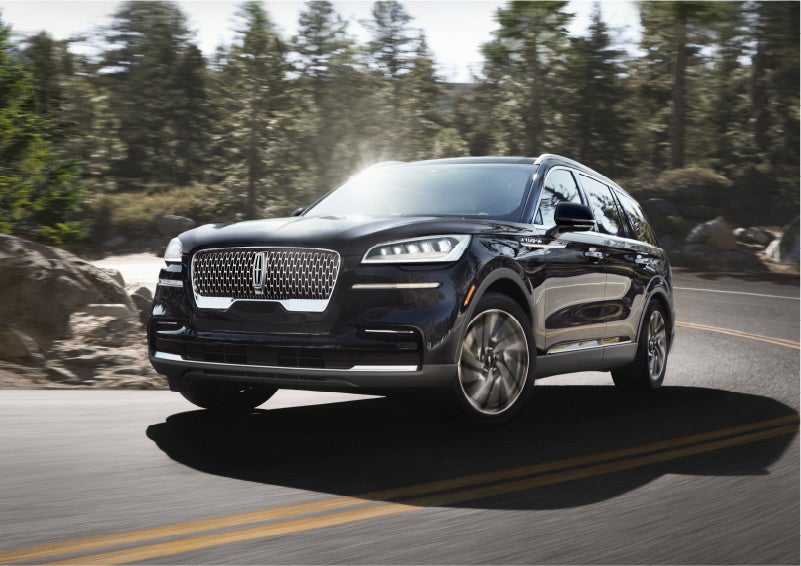 A Lincoln Aviator® SUV is being driven on a winding mountain road | Brinson Lincoln of Corsicana in Corsicana TX