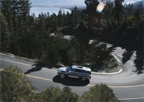 A 2023 Lincoln Aviator® SUV is being driven on a winding mountain road | Brinson Lincoln of Corsicana in Corsicana TX