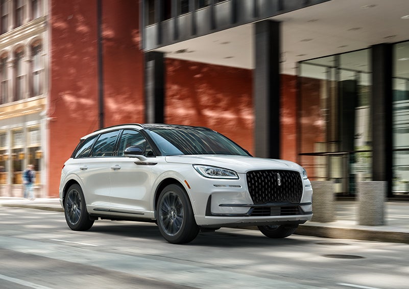 The 2024 Lincoln Corsair® SUV with the Jet Appearance Package and a Pristine White exterior is parked on a city street. | Brinson Lincoln of Corsicana in Corsicana TX